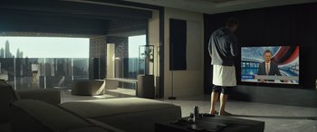 Movie still from “Kandahar” (2023), directed by Ric Roman Waugh – A man standing in front of a window in a living room; Wide shot, Low angle