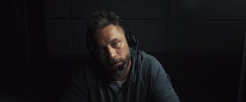Movie still from “Kandahar” (2023), directed by Ric Roman Waugh – A man with a beard wearing a headset; Close Up shot, Low angle