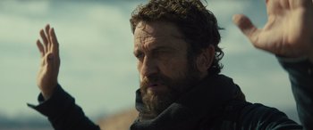 Movie still from “Kandahar” (2023), directed by Ric Roman Waugh – A person with a beard; Close Up shot, Over the shoulder angle