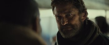 Movie still from “Kandahar” (2023), directed by Ric Roman Waugh – A person with a beard; Close Up shot, Over the shoulder angle