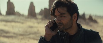 Movie still from “Kandahar” (2023), directed by Ric Roman Waugh – A person talking on a cell phone; Close Up shot, Low angle