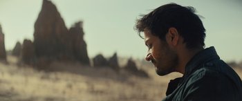 Movie still from “Kandahar” (2023), directed by Ric Roman Waugh – A person in a field; Close Up shot, Over the shoulder angle