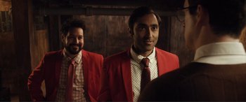 A man in a red jacket and a man in a white shirt and tie