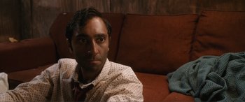 A person sitting on a couch wearing a tie
