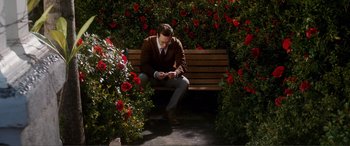 A man sitting on top of a wooden park bench
