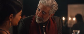 Movie still from “Khufiya” (2023), directed by Vishal Bhardwaj – An older man with white hair and a red scarf; Close Up shot, Over the shoulder angle