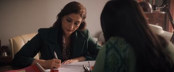 Movie still from “Khufiya” (2023), directed by Vishal Bhardwaj – A woman writing on a piece of paper while sitting at a table; Close Up shot, Over the shoulder angle
