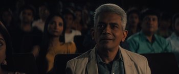 Movie still from “Khufiya” (2023), directed by Vishal Bhardwaj – An older man is sitting in front of a group of people; Close Up shot, Low angle
