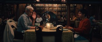 Movie still from “Khufiya” (2023), directed by Vishal Bhardwaj – Two people sitting at a table with a lit candle; Medium shot, Over the shoulder angle