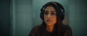 Movie still from “Khufiya” (2023), directed by Vishal Bhardwaj – A woman wearing headphones and looking into the distance; Close Up shot, High angle