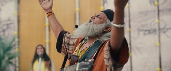 Movie still from “Khufiya” (2023), directed by Vishal Bhardwaj – An old man with a beard is holding a guitar; Medium shot, Low angle