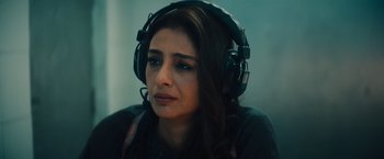 Movie still from “Khufiya” (2023), directed by Vishal Bhardwaj – A woman wearing headphones and looking sad; Close Up shot, High angle