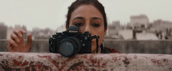 Movie still from “Khufiya” (2023), directed by Vishal Bhardwaj – A woman taking a picture with a nikon camera; Close Up shot, Low angle
