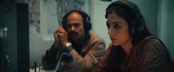 Movie still from “Khufiya” (2023), directed by Vishal Bhardwaj – A man and a woman wearing headphones and sitting in a room; Close Up shot, Overhead angle