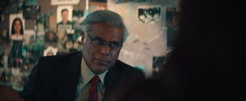 Movie still from “Khufiya” (2023), directed by Vishal Bhardwaj – A man in a suit and tie sitting in front of a wall; Close Up shot, Over the shoulder angle