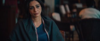 Movie still from “Khufiya” (2023), directed by Vishal Bhardwaj – A person sitting in a chair wearing a scarf; Close Up shot, Over the shoulder angle