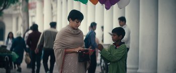 Movie still from “Khufiya” (2023), directed by Vishal Bhardwaj – A woman and a boy standing next to each other under balloons; Medium shot, Low angle
