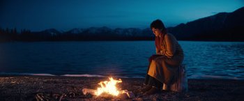Movie still from “Khufiya” (2023), directed by Vishal Bhardwaj – A woman sitting on the ground near a fire; Wide shot, Low angle