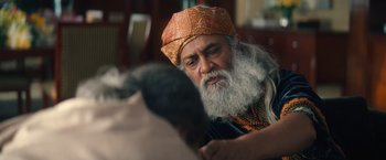 Movie still from “Khufiya” (2023), directed by Vishal Bhardwaj – An old man with a long white beard wearing an orange hat; Close Up shot, Over the shoulder angle