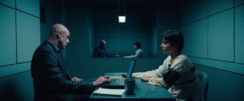 Movie still from “Khufiya” (2023), directed by Vishal Bhardwaj – Two people sitting at a table in front of a laptop computer; Wide shot, Over the shoulder angle