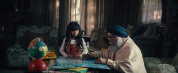 Movie still from “Khufiya” (2023), directed by Vishal Bhardwaj – An old man and a young girl sitting at a table; Medium shot, High angle