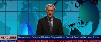 Movie still from “Khufiya” (2023), directed by Vishal Bhardwaj – A man in a suit and tie standing in front of a news desk; Medium shot, Over the shoulder angle