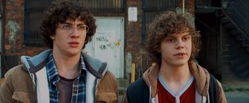 Movie still from “Kick-Ass” (2010), directed by Matthew Vaughn – Two young men standing next to each other in front of a building; Close Up shot, Over the shoulder angle