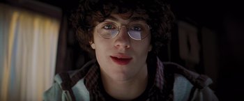 Movie still from “Kick-Ass” (2010), directed by Matthew Vaughn – A young man wearing glasses and a curly wig; Close Up shot, Low angle