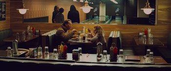 Movie still from “Kick-Ass” (2010), directed by Matthew Vaughn – A man and a woman sitting at a table eating; Wide shot, High angle