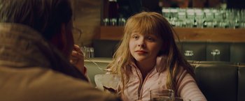 Movie still from “Kick-Ass” (2010), directed by Matthew Vaughn – A young girl sitting at a table eating ice cream; Close Up shot, Over the shoulder angle