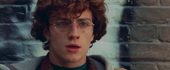 Movie still from “Kick-Ass” (2010), directed by Matthew Vaughn – A person wearing glasses; Close Up shot, Low angle