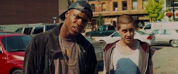 Movie still from “Kick-Ass” (2010), directed by Matthew Vaughn – Two young men standing next to each other on the street; Medium shot, Low angle