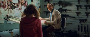 Movie still from “Kick-Ass” (2010), directed by Matthew Vaughn – A man sitting at a table with a young girl; Medium shot, Over the shoulder angle