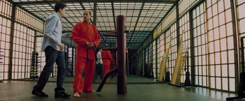 Movie still from “Kick-Ass” (2010), directed by Matthew Vaughn – A man that is standing in a room; Wide shot, Low angle