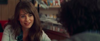 Movie still from “Kick-Ass” (2010), directed by Matthew Vaughn – A woman sitting in front of a counter with other people; Close Up shot, Over the shoulder angle