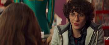 Movie still from “Kick-Ass” (2010), directed by Matthew Vaughn – A man with curly hair and glasses sitting in front of a woman; Close Up shot, Over the shoulder angle