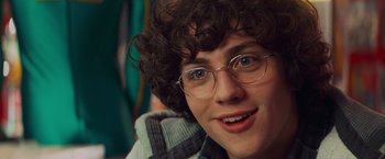 Movie still from “Kick-Ass” (2010), directed by Matthew Vaughn – A person wearing glasses and smiling; Close Up shot, Over the shoulder angle