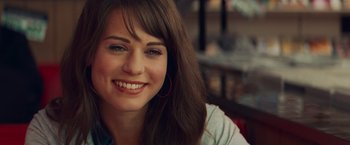 Movie still from “Kick-Ass” (2010), directed by Matthew Vaughn – A person with a smile on their face; Close Up shot, Over the shoulder angle