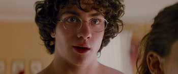 Movie still from “Kick-Ass” (2010), directed by Matthew Vaughn – A person wearing glasses and looking at the camera; Close Up shot, Low angle