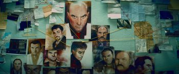 Movie still from “Kick-Ass” (2010), directed by Matthew Vaughn – A bunch of pictures that are on a wall; Extreme Close Up shot, Overhead angle