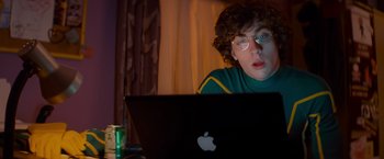 Movie still from “Kick-Ass” (2010), directed by Matthew Vaughn – A person sitting in front of an open laptop computer; Medium shot, Over the shoulder angle