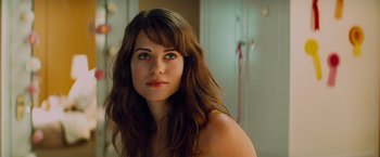 Movie still from “Kick-Ass” (2010), directed by Matthew Vaughn – A beautiful woman with long brown wavy hair; Close Up shot, Over the shoulder angle