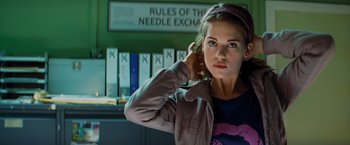 Movie still from “Kick-Ass” (2010), directed by Matthew Vaughn – A woman standing in front of a bunch of files; Close Up shot, Low angle