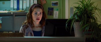 Movie still from “Kick-Ass” (2010), directed by Matthew Vaughn – A young girl sitting in front of a laptop computer; Close Up shot, Over the shoulder angle
