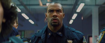 Movie still from “Kick-Ass” (2010), directed by Matthew Vaughn – A man that is wearing a police uniform; Close Up shot, Low angle