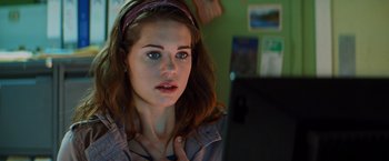 Movie still from “Kick-Ass” (2010), directed by Matthew Vaughn – A woman with a headband is looking at a laptop; Close Up shot, Over the shoulder angle