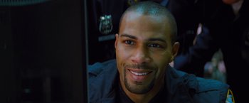 Movie still from “Kick-Ass” (2010), directed by Matthew Vaughn – A person smiling for the camera; Close Up shot, Over the shoulder angle