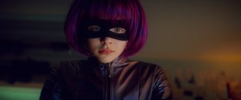 Movie still from “Kick-Ass” (2010), directed by Matthew Vaughn – A woman with purple hair wearing a purple mask; Close Up shot, Low angle