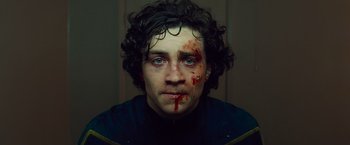 Movie still from “Kick-Ass” (2010), directed by Matthew Vaughn – A person with blood on his face; Close Up shot, Low angle