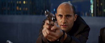 Movie still from “Kick-Ass” (2010), directed by Matthew Vaughn – A man holding a gun in his right hand; Close Up shot, Low angle